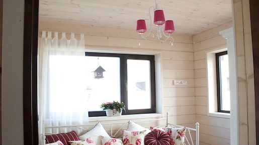 Vierashuone on saanut romanttisen ilmeen kukkakuoseilla ja vaaleilla väreillä. Pinkki kattokruunu istuu siihen saumattomasti.