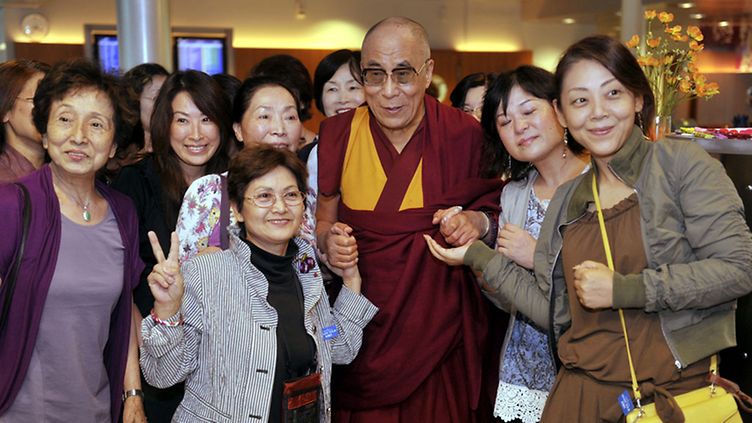 Tiibetin hengellinen johtaja dalai-lama, Tenzin Gyatso, ja japanilaisia turisteja, jotka halusivat yhteiskuvaan dalai-laman kanssa Helsinki-Vantaan lentokentällä 18. elokuuta 2011.