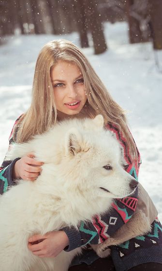 Nainen talvisessa metsässä koiran kanssa