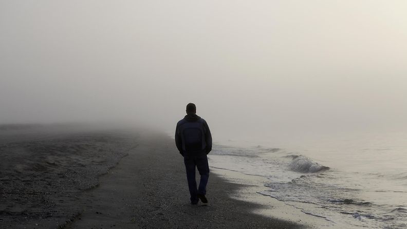 yksinäinen mies rannalla