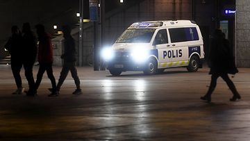 Poliisiauto ja jalankulkijoita Helsingin Narinkkatorilla.