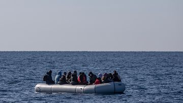 Turkin rannikkovartiosto pelastaa siirtolaisia kumiveneellä. Vene on tupaten täynnä ja ympärillä pelkkää merta. 