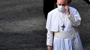 Paavi Franciscus korjaa kasvomaskiaan.
