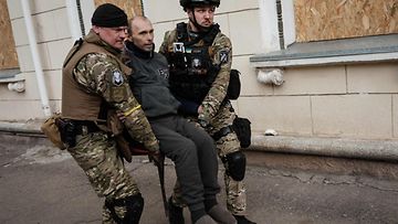 Poliisit kantoivat evakuoitavaa miestä Lysychanskissa, Itä-Ukrainassa, 15. toukokuuta.