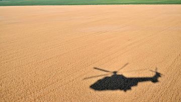 LK 15.7.2022 Helikopterin varjo viljapellolla Kiovan alueella Ukrainassa 14.7.2022.