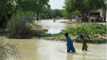 Lapsia tulvavesien keskellä Pakistanissa.