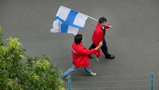 Japanilaiset kantavat Suomen lippua.